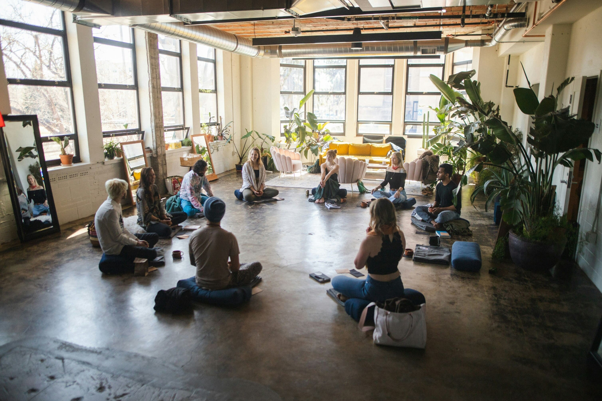 Cercle d'atelier dans un espace lumineux : groupe assis en cercle pour un temps de partage